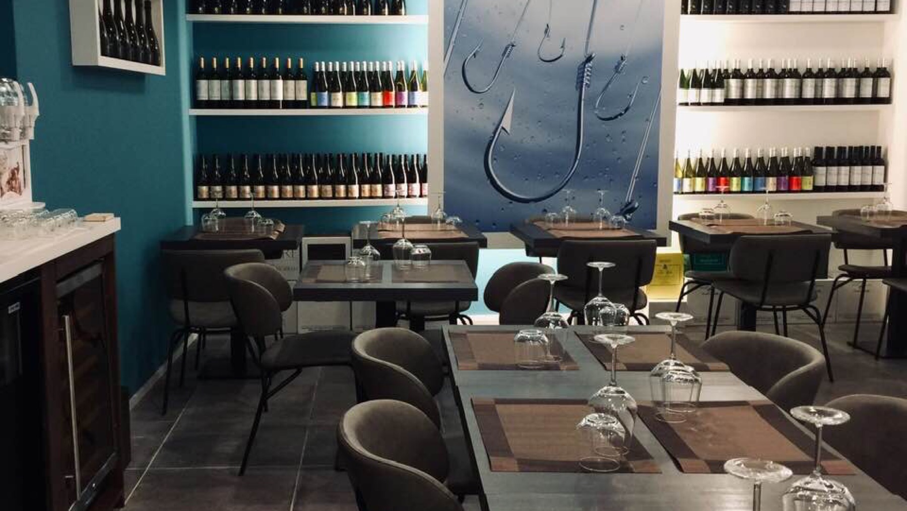 L'interno di L'Amo Osteria di Mare, con la parete a tema pesca